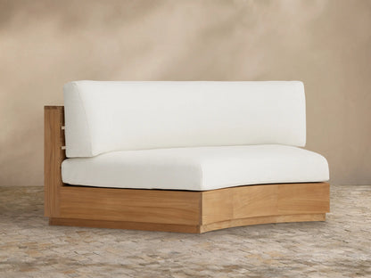 Bal Harbour Outdoor Curved Sofa section, light teak wood base with white cushions, angled on a tiled floor.