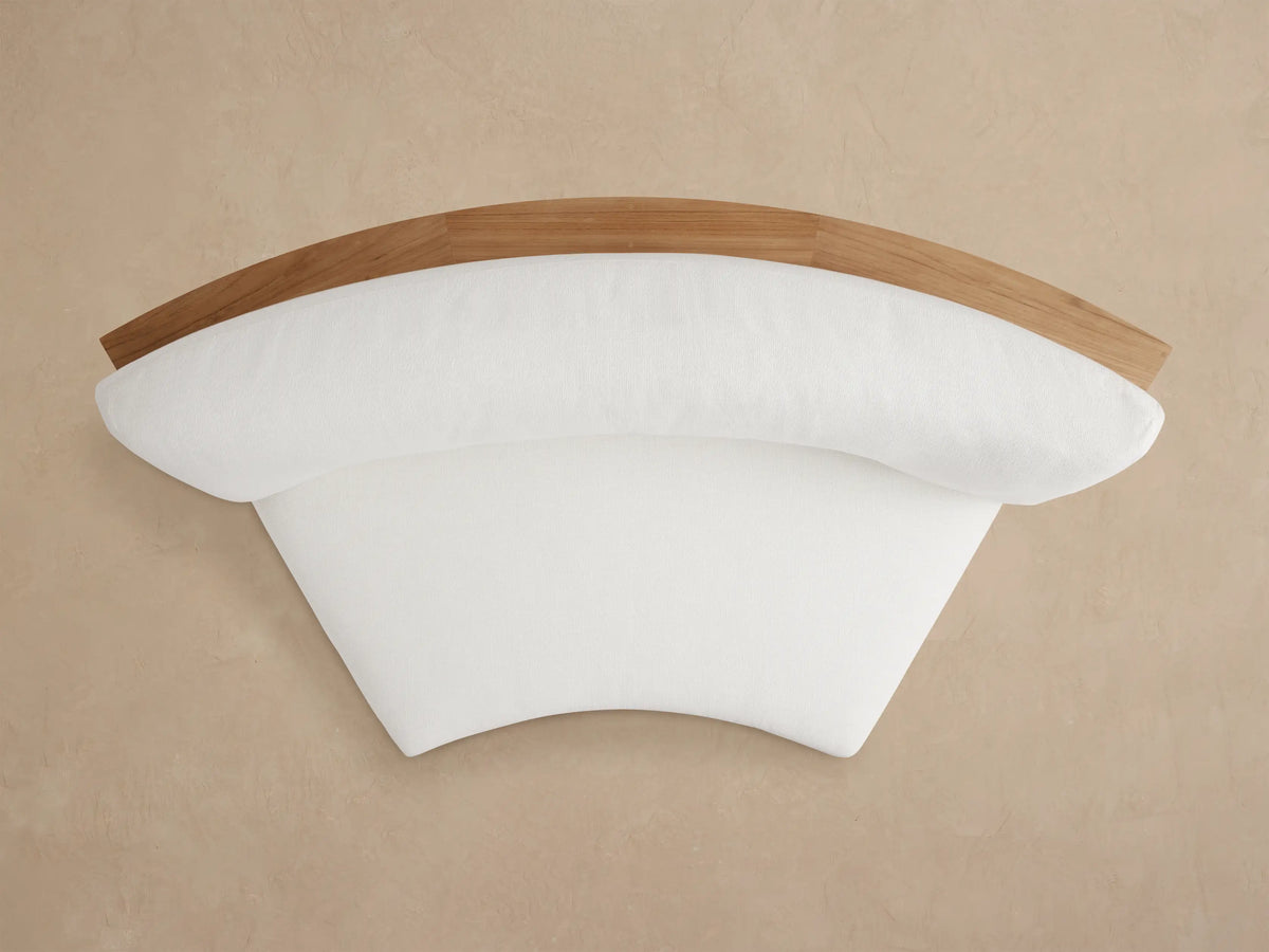 Bal Harbour Outdoor Curved Sofa, rear view. Natural teak wood slatted back and curved base, with white cushions.