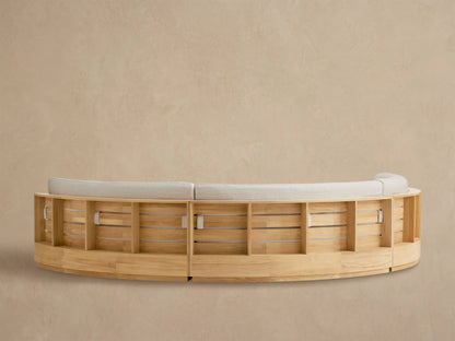 Close-up of Bal Harbour Outdoor Curved Sectional. Light wood armrest & textured beige fabric back cushion are visible.