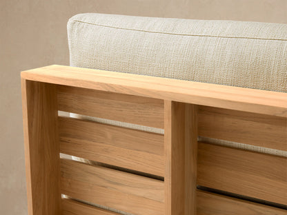 Bal Harbour Outdoor Teak Armless Chair with golden teak base and light beige fabric seat/back cushions, front view.