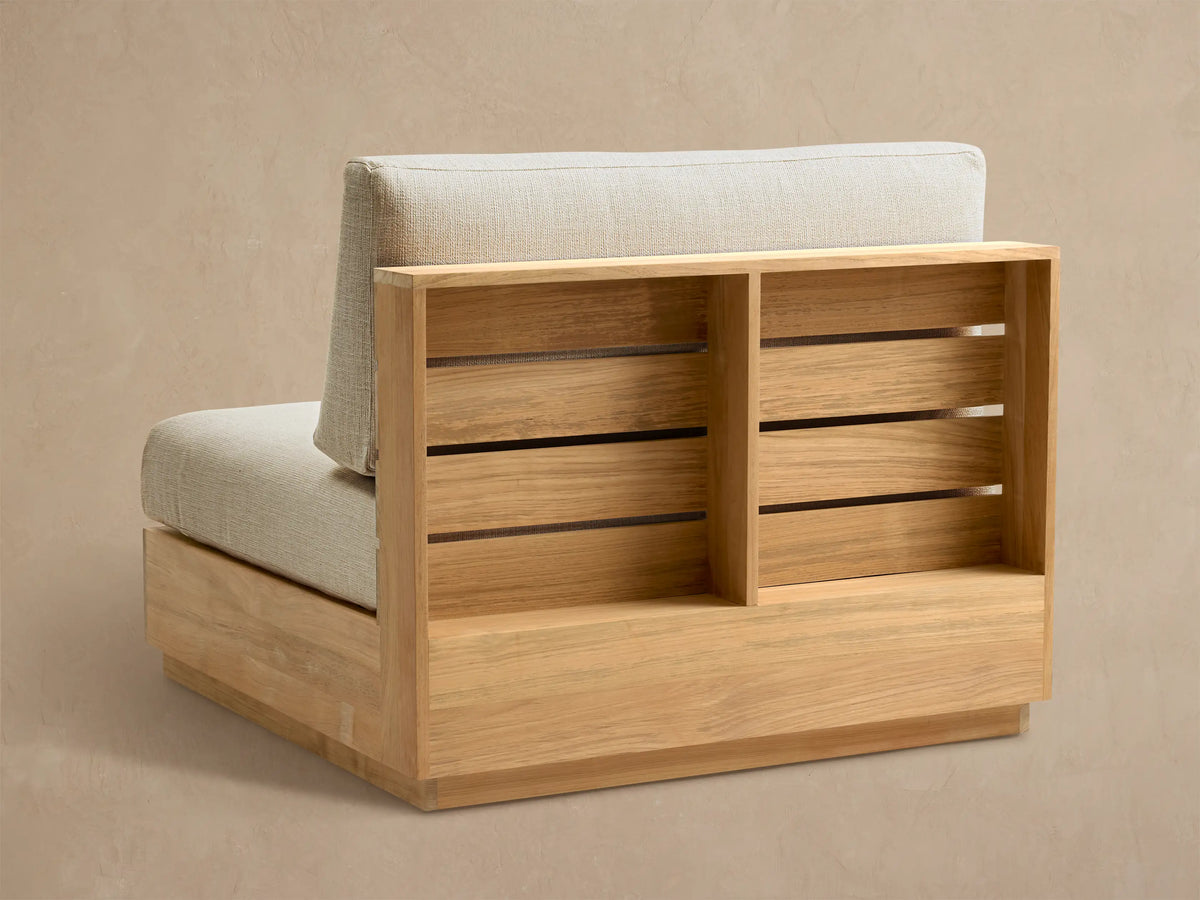 Close-up of Bal Harbour Outdoor Teak Armless Chair, showing its light golden teak wood slatted back and beige cushion.