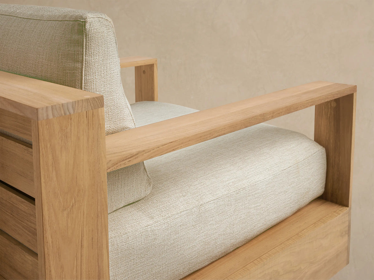 Bal Harbour Outdoor Teak Swivel Chair, front view. Natural teak wood frame with block arms, light beige cushions, and swivel base.