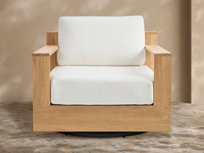Bal Harbour Outdoor Teak Swivel Chair: Natural teak frame, white seat and back cushions, black swivel base on stone floor.