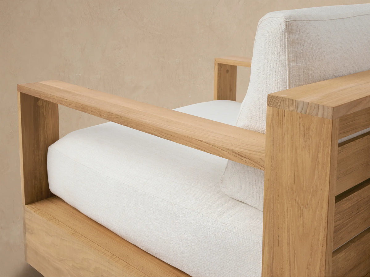 Bal Harbour Outdoor Teak Swivel Chair with light teak frame, textured white cushions, and visible black swivel base.