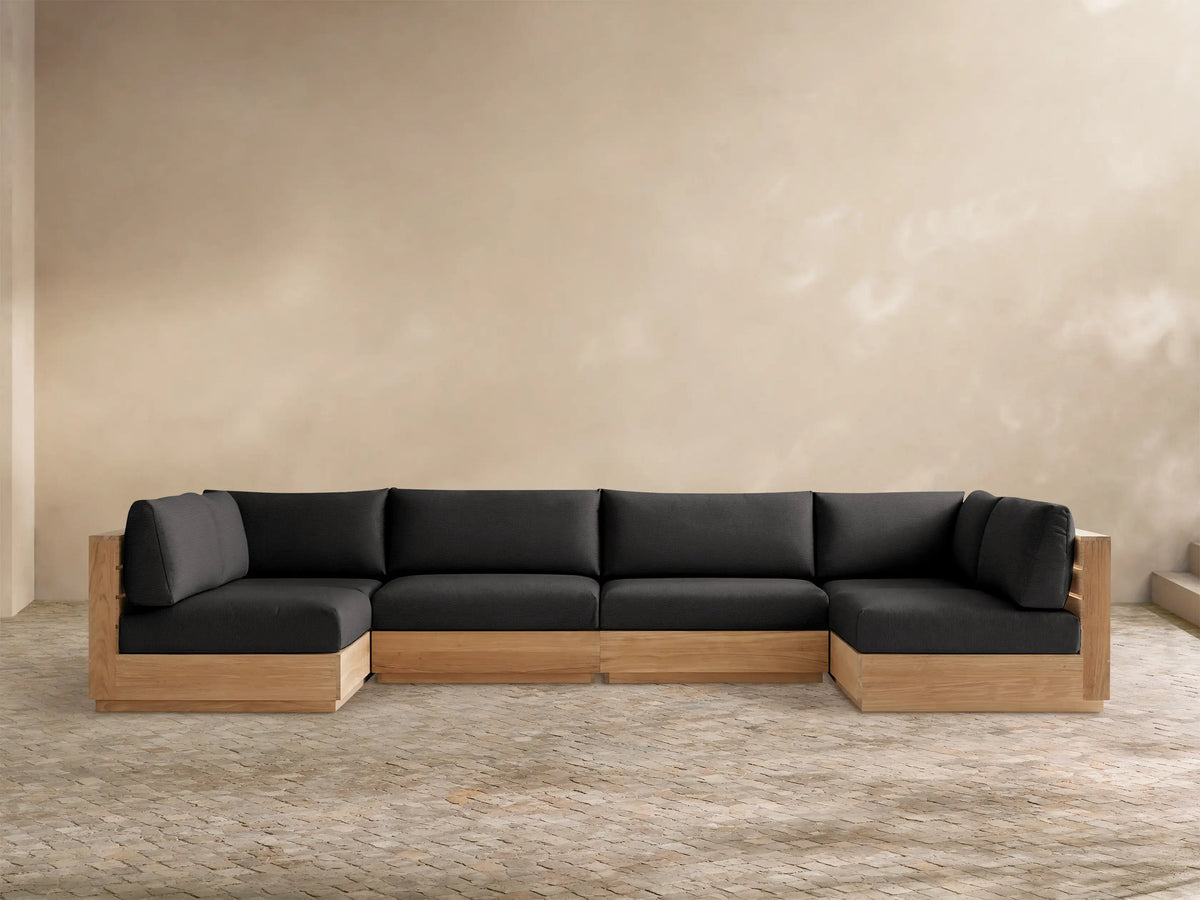 Bal Harbour Outdoor Teak Six-Piece Sectional, U-shaped, with natural light teak frame and dark gray cushions on a tiled floor.