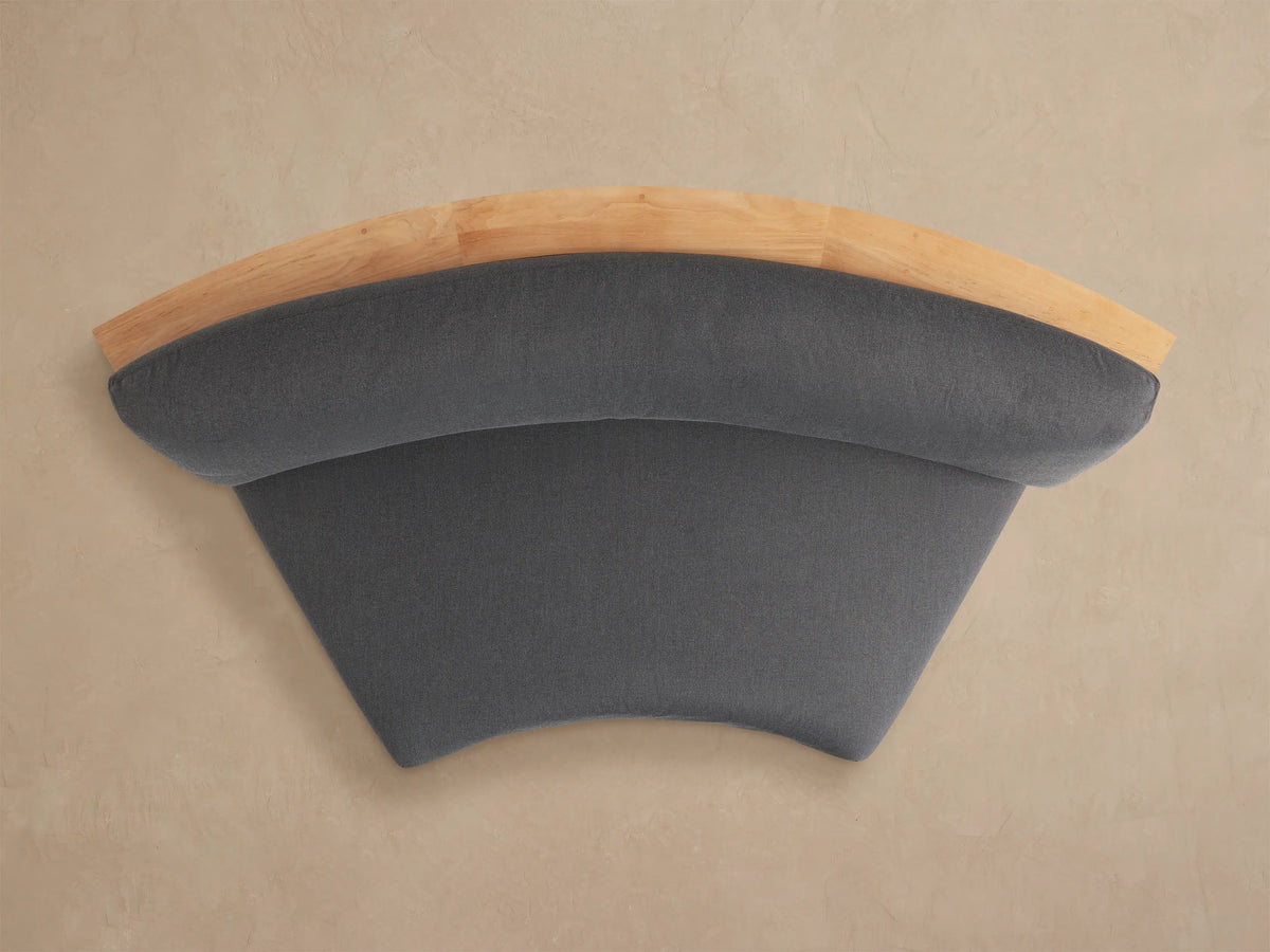 Rear view of Bal Harbour Curved Outdoor Sofa. Natural teak wood frame features built-in storage shelves. Dark gray cushions visible.
