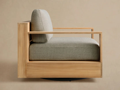 Side view of the natural teak Bal Harbour Outdoor Teak Swivel Chair with light green-gray textured cushions and slatted wooden frame.