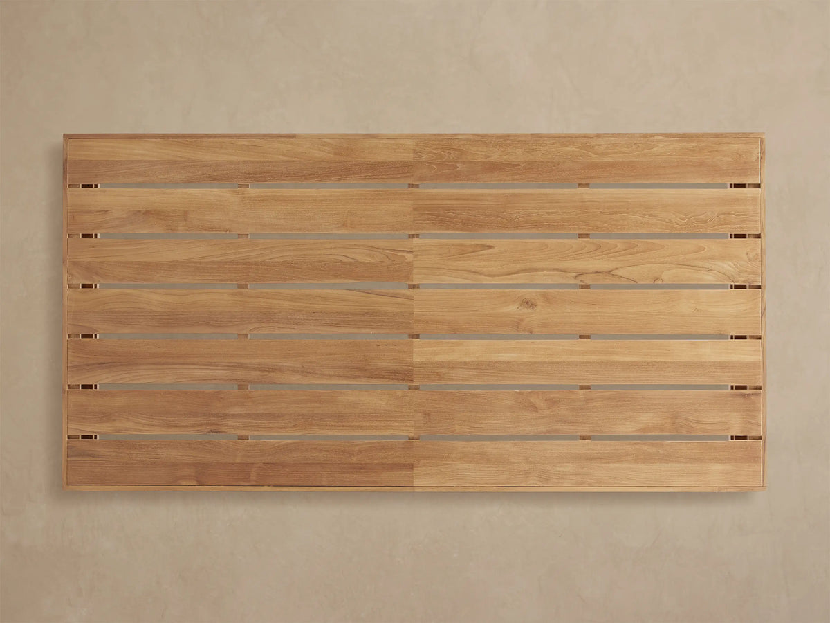 Close-up, angled view of Bal Harbour Outdoor Teak Coffee Table. Shows warm golden-brown slatted top and smooth side.