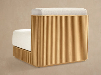 Close-up of Beaumont Outdoor Teak Lounge Chair with golden teak frame, vertical slats, rounded corner, light cream cushions.