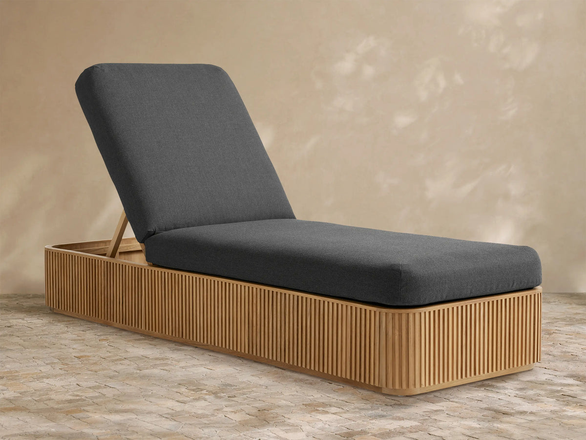 Rectangular light grey Beaumont Outdoor Collection Cover on outdoor furniture, on a stone patio, against a tan wall.