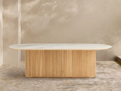 Beaumont Outdoor Teak Dining Table: Oval white marbled top on a natural golden fluted teak wood pedestal base, outdoor patio.