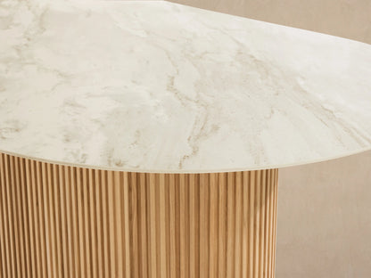 Beaumont Outdoor Teak Dining Table: oval white sintered stone top, fluted natural teak base, angled view on tiled floor.