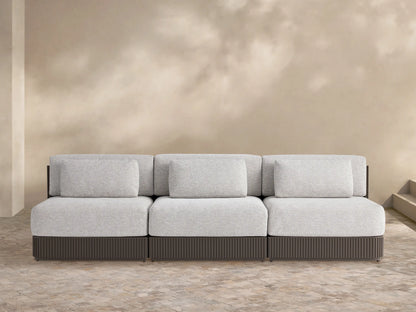 Beaumont Outdoor Aluminum Three-Piece Modular Sofa in light gray with a dark brown slatted aluminum base on a tiled patio.