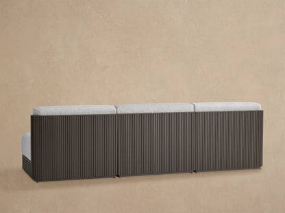 Close-up of Beaumont Modular Sofa. Dark brown aluminum frame with vertical slats, light grey textured seat and back cushions.
