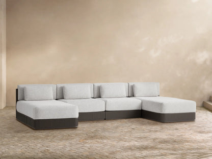 Beaumont 4-piece double chaise sectional with light gray cushions and a dark gray ribbed base, L-shaped on tiled floor.