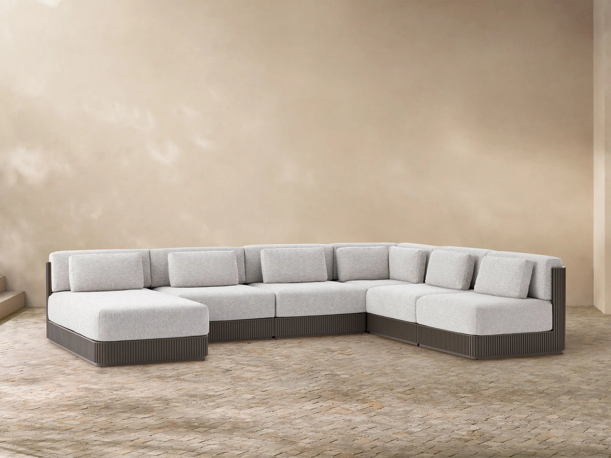 Beaumont Outdoor Aluminum Six-Piece Sectional with Chaise. Light gray cushions, dark gray slatted base, U-shaped on a tiled floor.