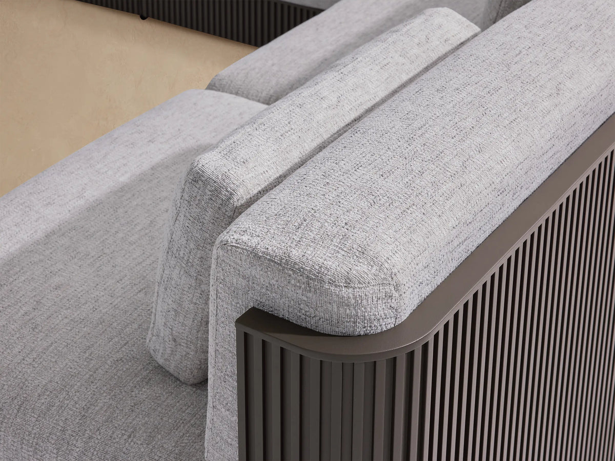 Beaumont Outdoor Aluminum Six-Piece Sectional with Chaise. L-shaped sofa with light gray cushions, dark brown slatted frame on a tiled patio.