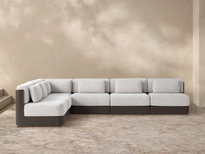 L-shaped Beaumont Outdoor Aluminum Six-Piece Sectional with light grey cushions & dark ribbed aluminum frame on patio stones.