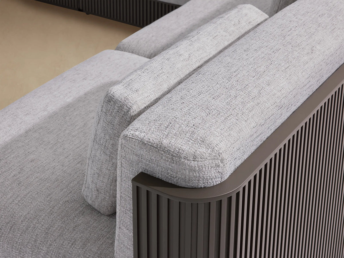 Beaumont 6-piece outdoor sectional with light gray cushions, dark fluted aluminum frame, and a chaise, on a patio.