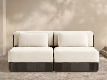 Beaumont two-piece modular sofa with light cream cushions, dark brown ribbed base, on an outdoor patio.