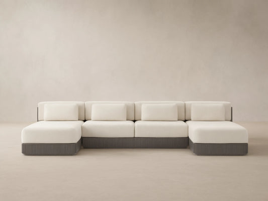 Beaumont 4-piece outdoor double chaise sectional, cream cushions, dark gray ridged aluminum base, facing forward on a patio.