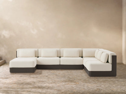Beaumont six-piece L-shaped outdoor sectional with cream cushions, dark brown slatted aluminum base, on a stone patio.