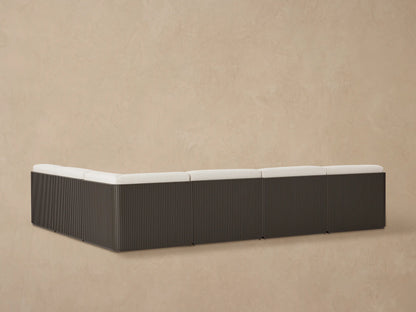 Close-up of Beaumont sectional's light beige textured cushions on a dark slatted aluminum frame, viewed from above.