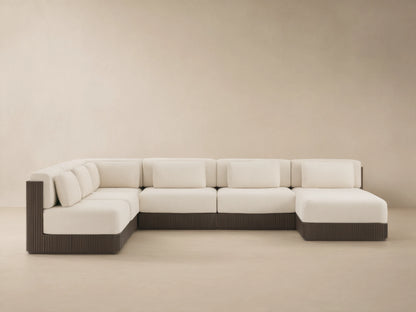 Beaumont six-piece L-shaped outdoor sectional with cream cushions, dark brown slatted aluminum base, on a stone patio.