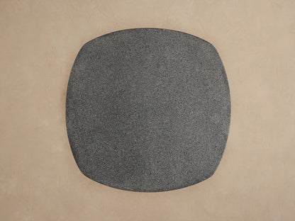 Angled close-up of Bellagio Outdoor End Table. Dark gray, speckled rounded top & textured, patterned cylindrical base.