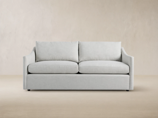 Light gray Branson Outdoor Sofa with two seat and two back cushions, modern clean lines, against a wooden shingle wall.