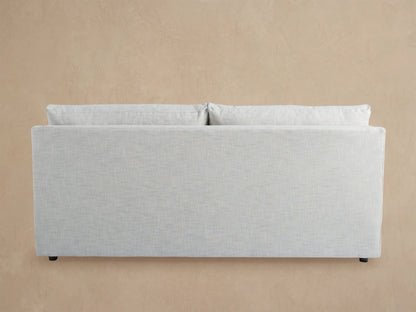 Light gray Branson Outdoor Sofa with two seat and two back cushions, modern clean lines, against a wooden shingle wall.