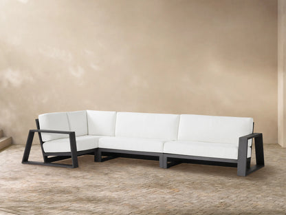 Canyon Outdoor Aluminum L-shaped three-piece sectional with dark gray frames and white cushions on a light-colored patio.