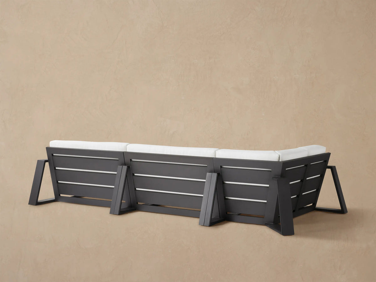 Canyon Outdoor Aluminum Three-Piece Sectional, close-up of corner with white textured cushions & dark gray frame.