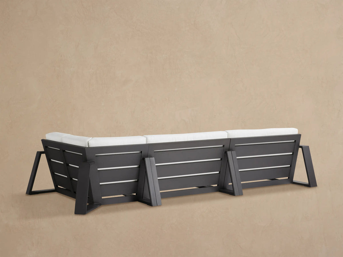 Close-up of Canyon Outdoor Aluminum Three-Piece Sectional with white cushions and dark gray frame, viewed from above.