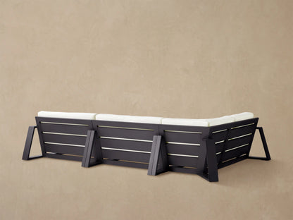 Close-up of the Canyon Outdoor Aluminum Three-Piece Sectional, showing plush white cushions and a sleek black frame.