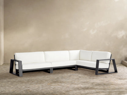 L-shaped Canyon Outdoor Sectional with dark gray frames & thick white cushions on a paved patio.