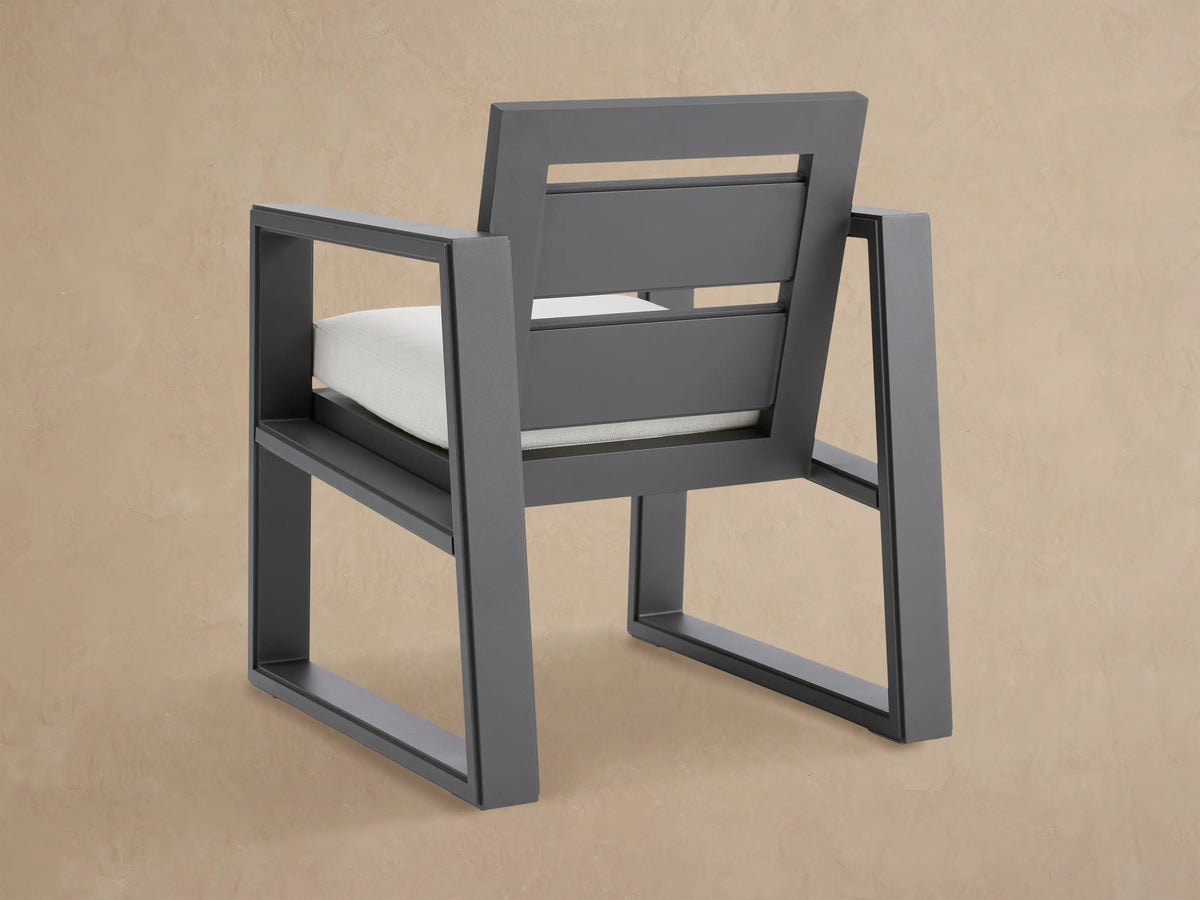 Canyon Outdoor Aluminum Dining Arm Chair, dark gray angular frame with slatted back and white seat cushion.