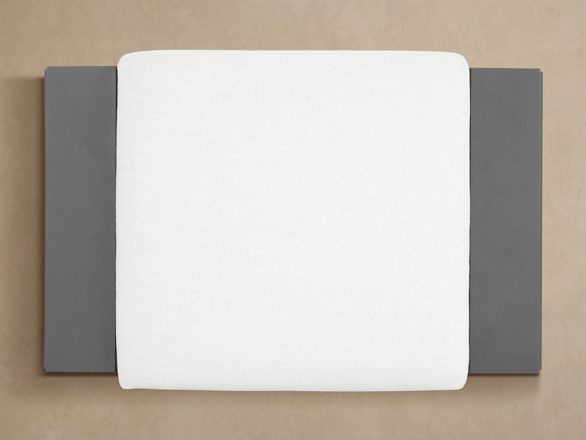 Canyon Outdoor Aluminum Ottoman: close-up of a white textured cushion on a dark gray angular aluminum frame.