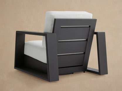 Angled view of Canyon Outdoor Aluminum Swivel Chair with dark gray slatted frame and light gray woven back cushion.