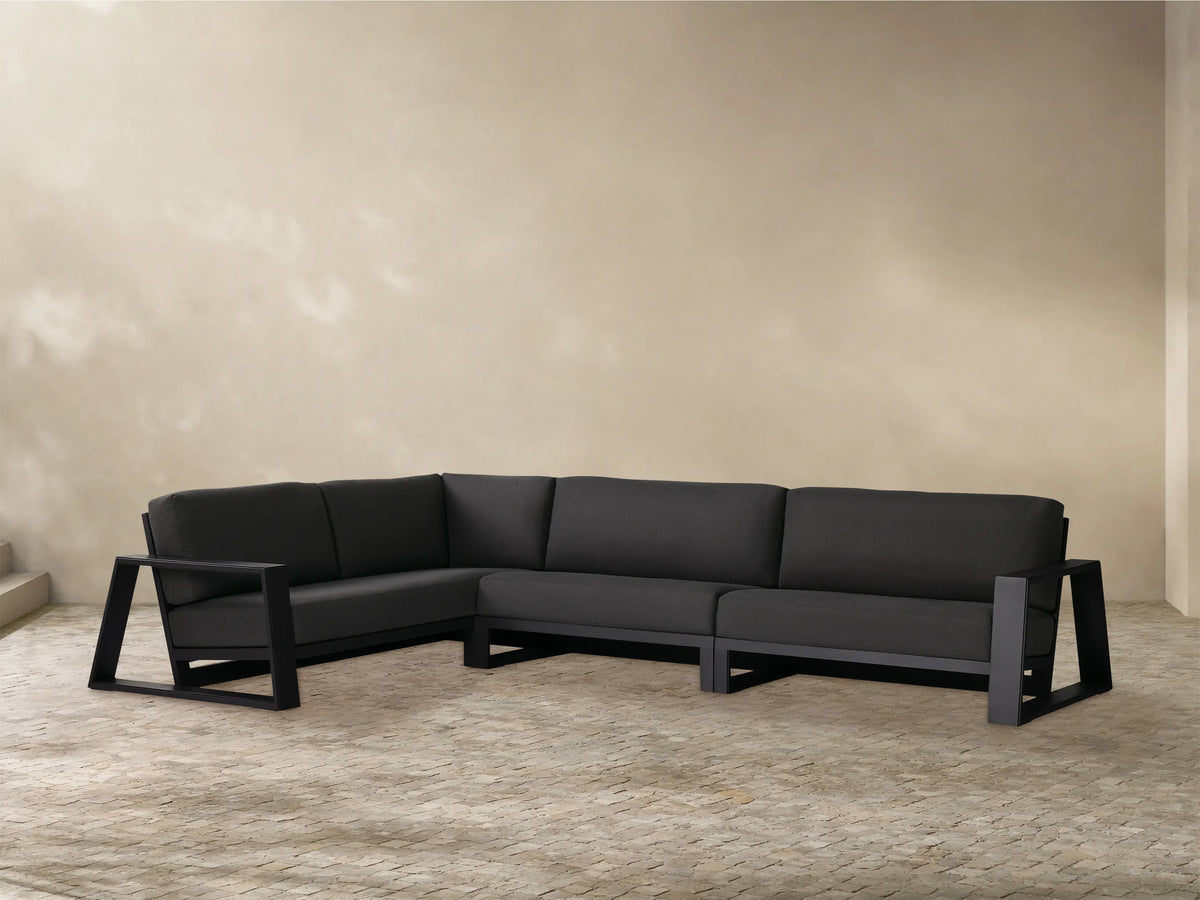 Dark gray Canyon Outdoor Aluminum Three-Piece Sectional, L-shaped, with modern angular frame on a tiled patio.