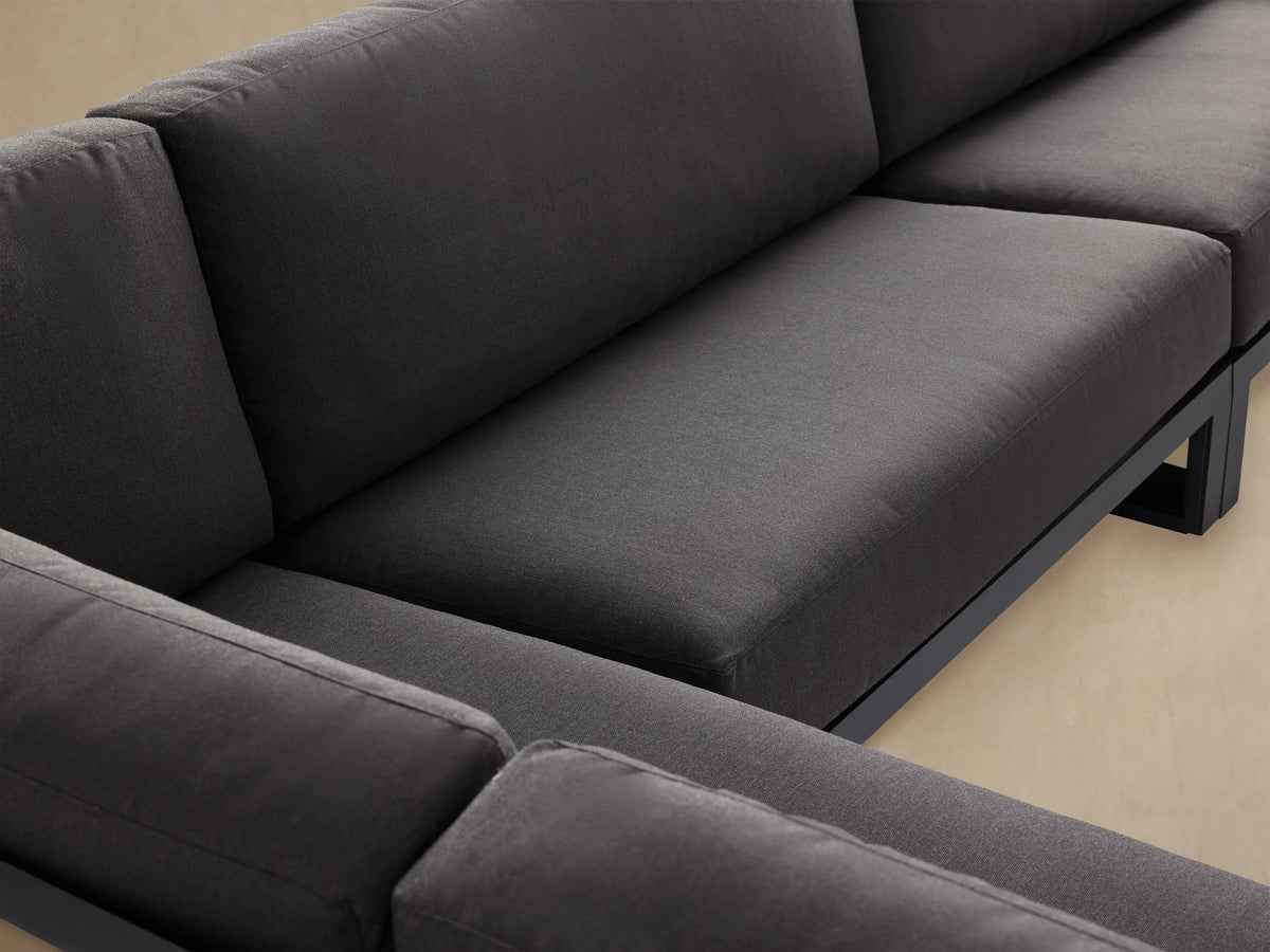 Canyon Outdoor Aluminum Sectional, L-shaped with dark grey cushions and modern black frames on a light tiled patio.