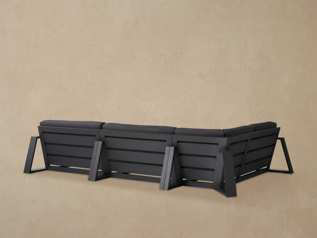 Close-up of a dark grey Canyon Outdoor Aluminum Three-Piece Sectional, showing thick cushions and black frame from an angle.