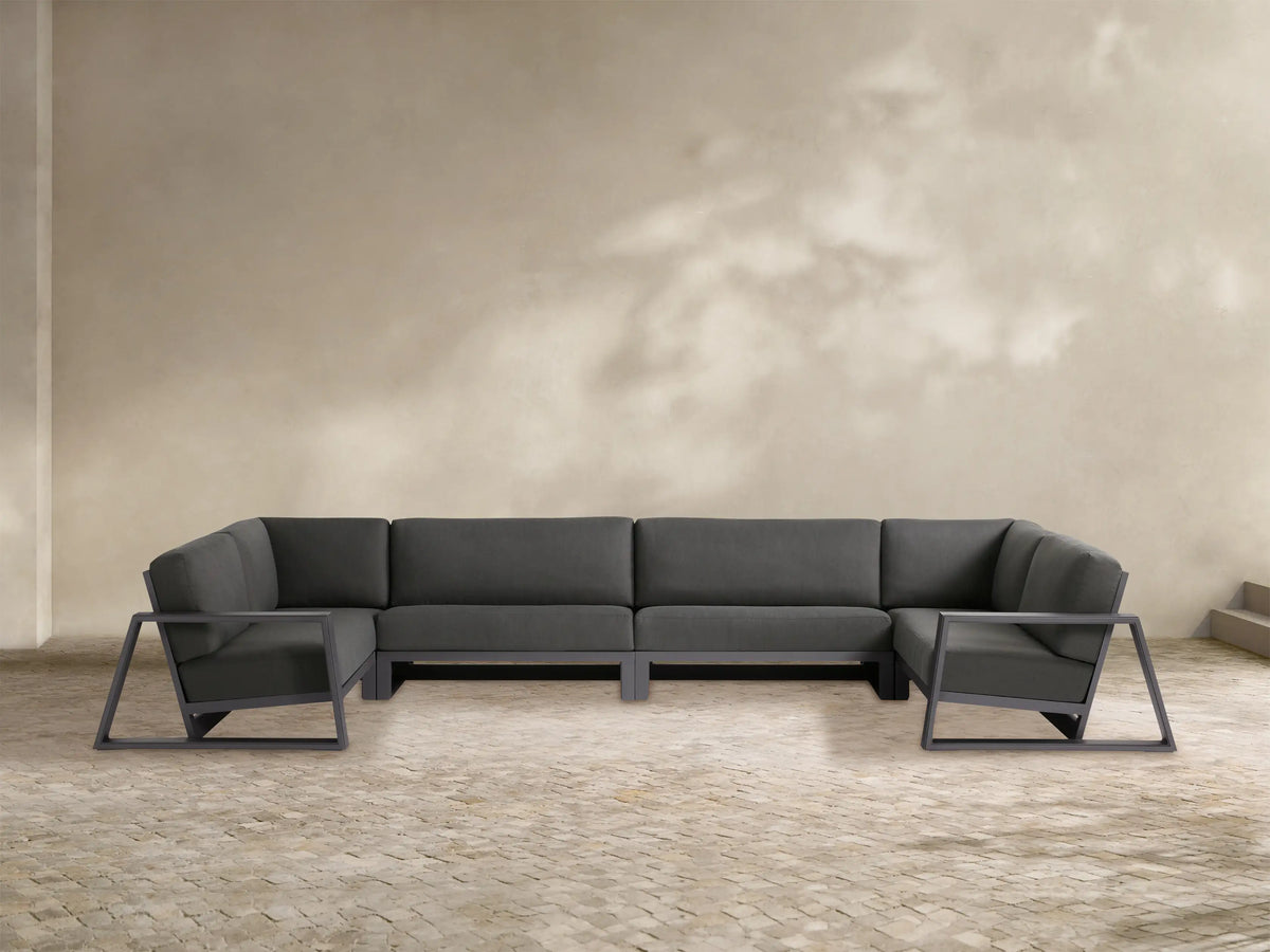 Canyon Outdoor Aluminum Four-Piece Sectional, dark gray cushions on visible charcoal aluminum frames, U-shaped on patio.