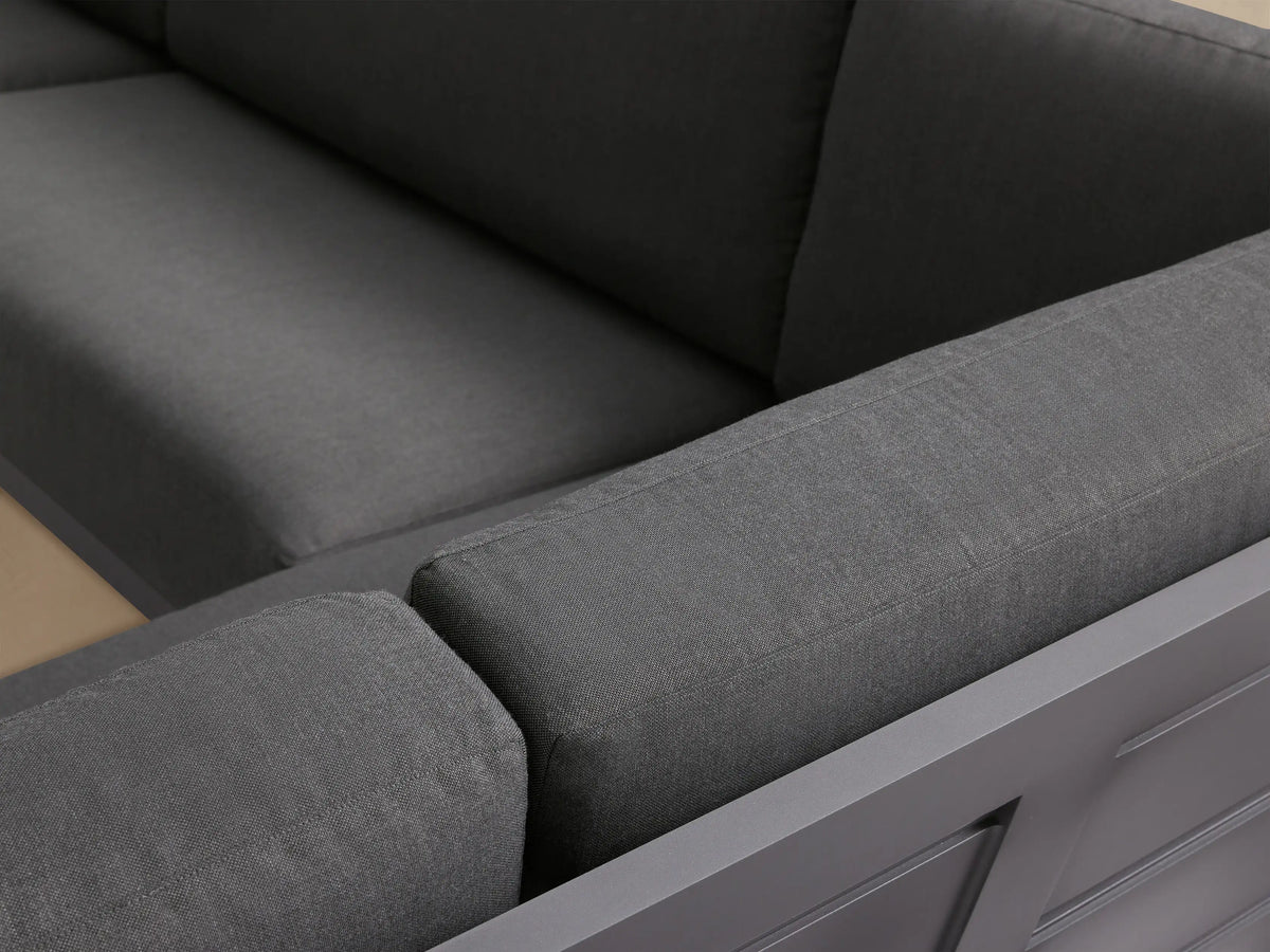 Canyon Outdoor Aluminum Four-Piece Sectional with dark gray frame and cushions, arranged in a large U-shape on a patio.