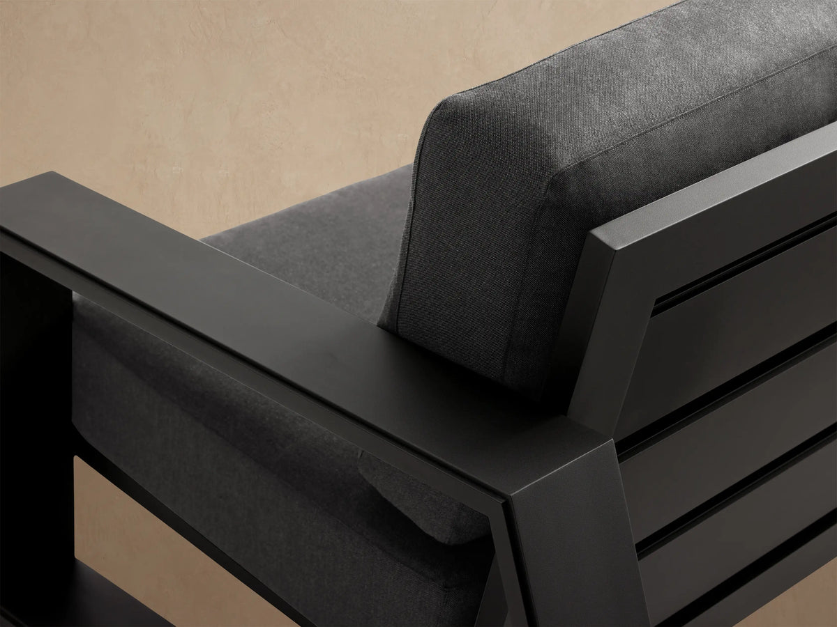 Modern Canyon Outdoor Aluminum Sofa with dark gray cushions and a sleek black aluminum frame, angled slightly right on a patio.