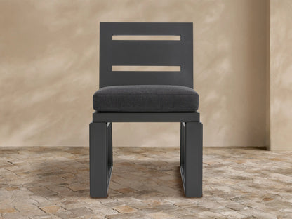 Canyon Outdoor Aluminum Dining Side Chair. Modern dark gray aluminum chair with two horizontal back slats & gray cushion on tiled floor.