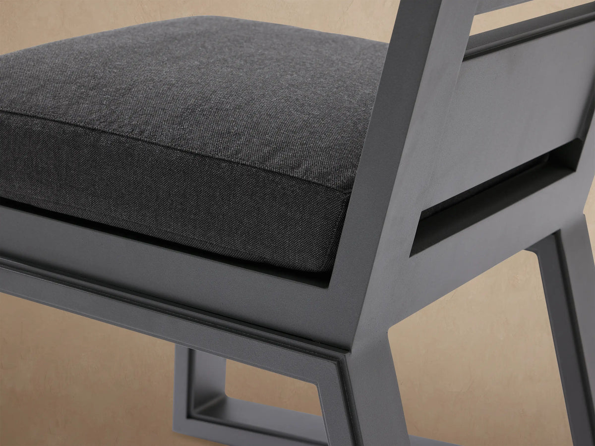 Front view of Canyon Outdoor Aluminum Dining Side Chair. Dark gray aluminum frame, two horizontal back slats, thick charcoal cushion.