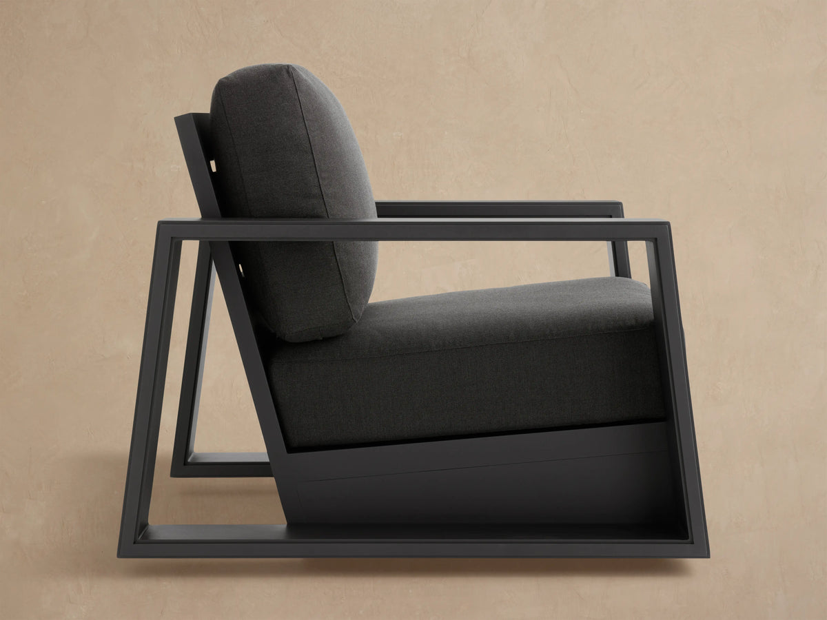 Canyon Outdoor Aluminum Swivel Chair, dark gray frame with slatted back and plush gray cushions, seen from the rear-side.