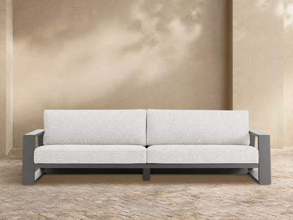 Canyon Outdoor Aluminum Sofa, two-seater, with a dark gray frame and light gray cushions on a patio setting.