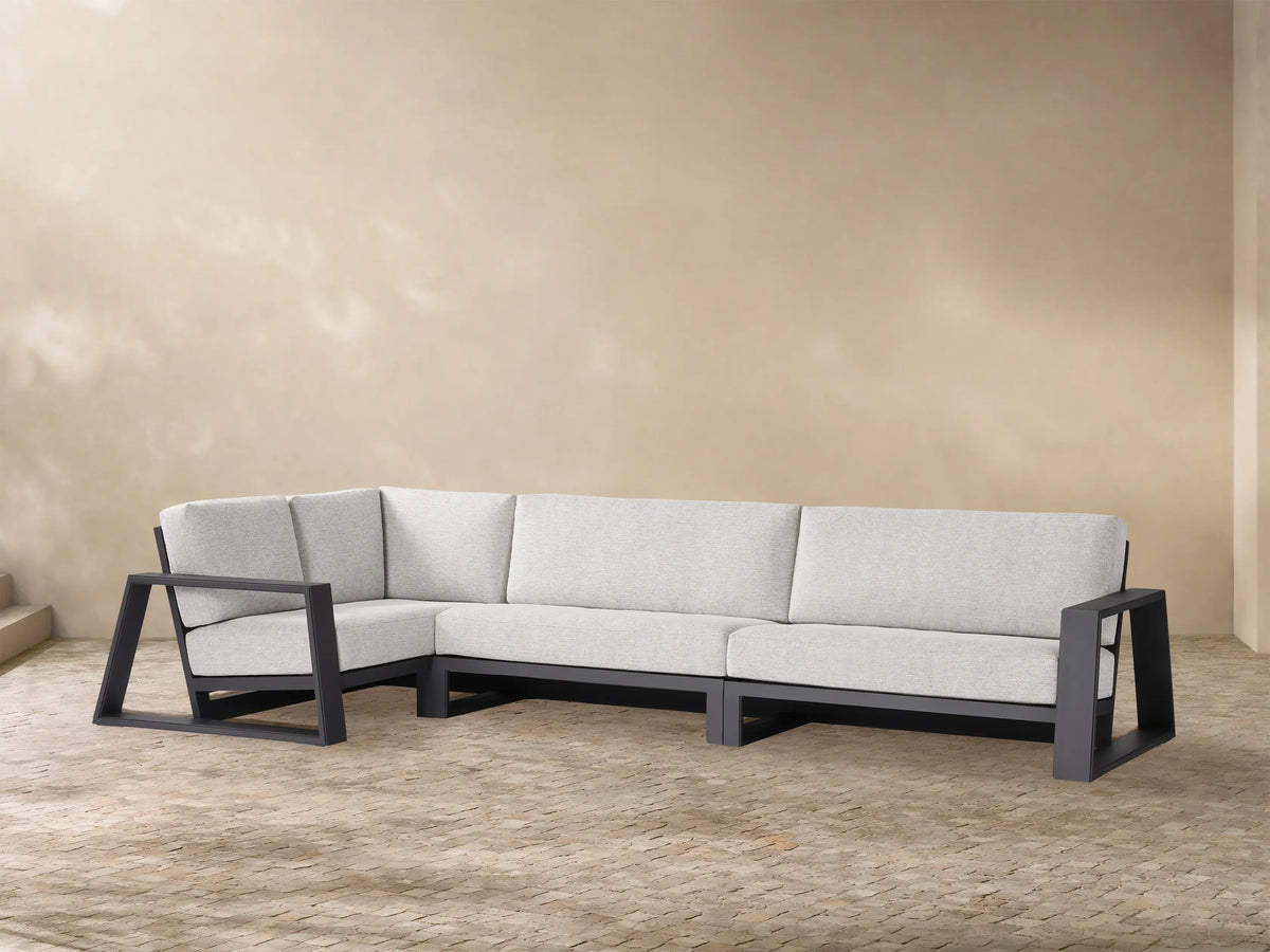 L-shaped Canyon Outdoor Aluminum Three-Piece Sectional with dark grey frame and light grey cushions on a patio.